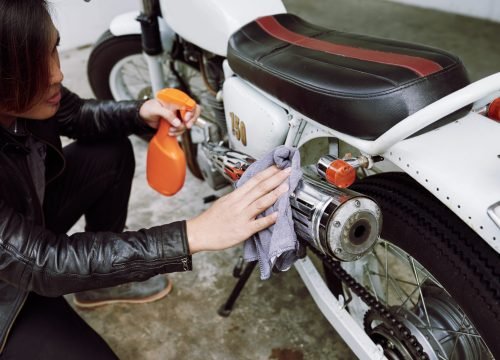top-angle-view-cropped-biker-polishing-pipe-his-motorcycle